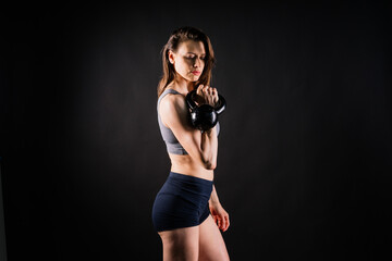 Fototapeta na wymiar Young female doing swing exercise with a kettle bell. Fitness woman