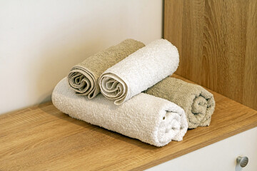 Clean folded towels on a shelf inside hotel room interior - 768269483