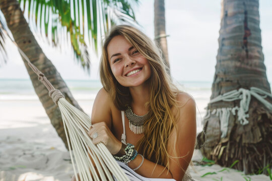Portrait of a beautiful young woman in a hammock on the beach
