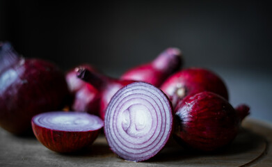 Purple onions on the wooden board. Close up. 