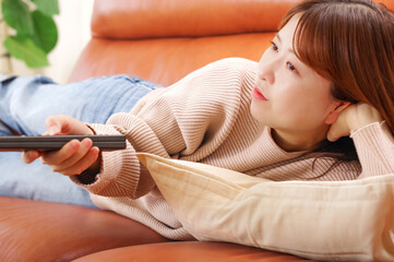 ソファーに座ってテレビを見る女性