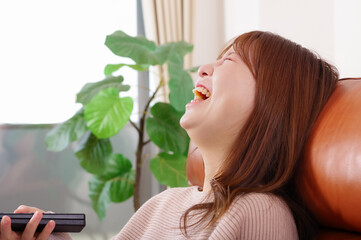 ソファーに座ってテレビを見る女性