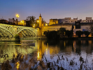 Old town over the Guadalquivir river, beautiful bridge at sunset in Seville, Andalusia, Spain