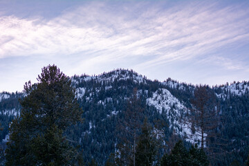 Snowy mountain with a partly cloudy purple and blue sky