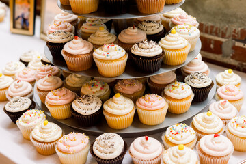 Stacks of delicious cupcakes on a tiered tray in different flavors. 