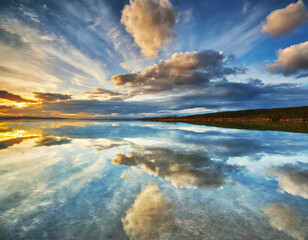 鏡のような水面とダイナミックに広がる空の美しい自然風景