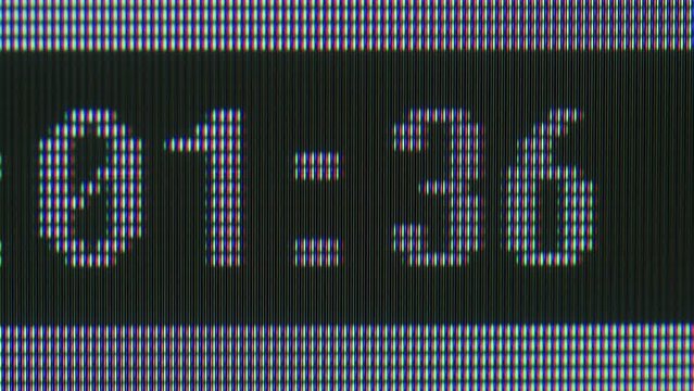 Pixel on old vintage computer monitor close-up. Time on black background macro. Desktop vintage retro wave display, late 90s PC.