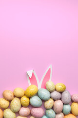 chocolate easter eggs with bunny ears on pink background