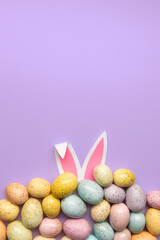 chocolate easter eggs with bunny ears on purple background