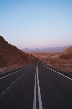 Shot of long road crossing mountains in Atacama desert, Chile