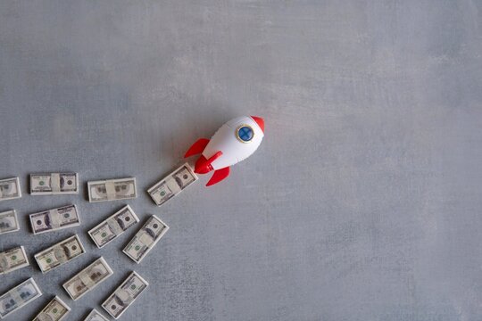 Rocket blasts off through a pile of money. Skyrocket sales, growing sales concept.