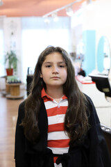 niño con pelo muy largo en la peluquería que va a donar el cabello para pelucas de mujeroes con cáncer