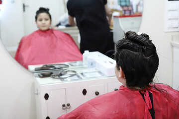 niño con el pelo largo cortándolo en la peluquería para donarlo para hacer pelucas para personas...