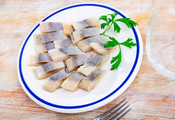 Closeup slices of slightly salted herring with parsley
