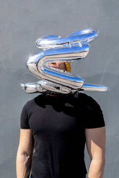 Anonymous man with silver love balloons over head