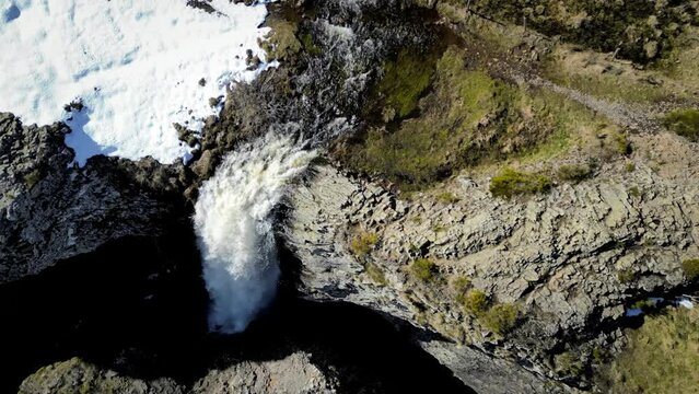 Waterfall seen from the sky to the vertical, on a small rocky cliff with water falling on a rock, filmed in the aubrac in France, 4K drone video
