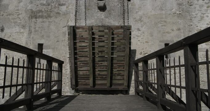 Rising draw bridge of ancient 14th century castle - dolly in, wide shot
