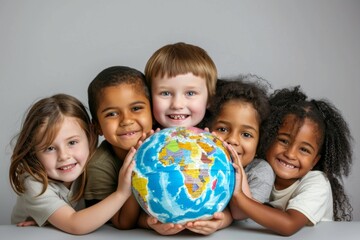 Fototapeta premium Group of diverse children smiling and holding a globe, representing friendship and togetherness