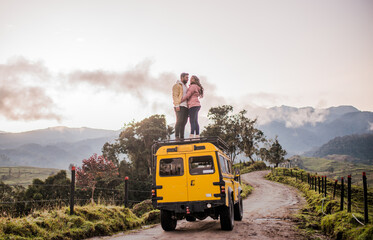 pareja en sima del techo del carro al aire libre en la montaña viajando de vacaciones 