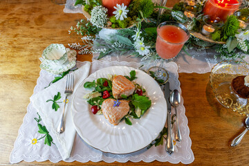Salmon hearts on a spring green salad served on fine China plates and crystal with gold inlay