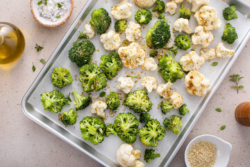 Broccoli and cauliflower florets on a sheet pan ready to be roasted