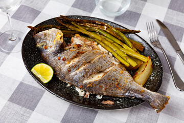 Lunch for one person is served on plate - fried dorado sea fish carcass, garnished with fried...