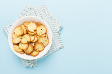 Spiced bruschette chips on color background, top view