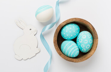 Blue easter eggs with bunny on white background, top view