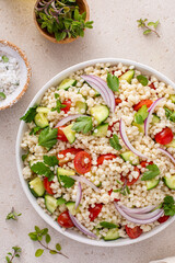 Pearl couscous salad with fresh vegetables and herbs, healthy side dish idea