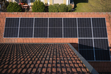 Solar panels on the roof of a house with red tiles