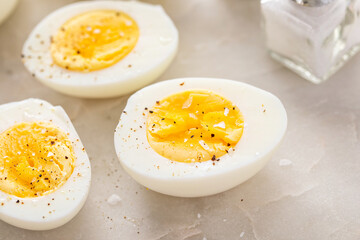 Boiled eggs peeled and cut in half with salt and pepper - 768332472