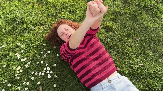 Young redhead woman enjoying a relaxing day in the park