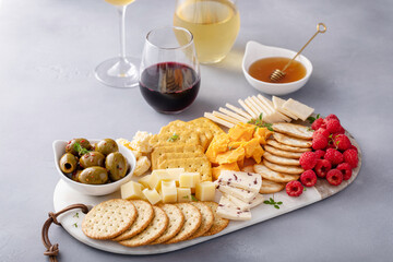 Cheese and snacks board with olives and crackers
