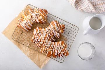 Tuinposter Bear claws pastry drizzled with sugar glaze and topped with almonds © fahrwasser