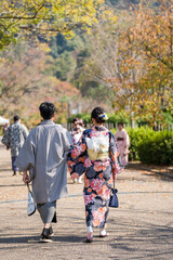 a couple walking down a path with a man and woman holding a dog.