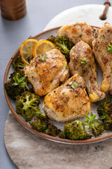 Chicken drumsticks and thighs with broccoli roasted on a serving plate for dinner or lunch
