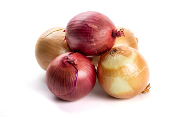 Red and yellow cooking onions in a pile isolated on white