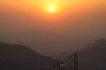 Obraz premium The sun is setting between the mountains