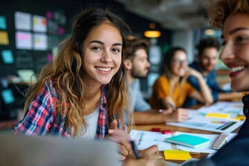 Fototapeta premium A bright-eyed young woman with a checked shirt smiles in a collaborative workspace