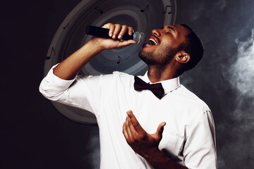 Singer's performance poster, stylish design. Man with microphone on dark background