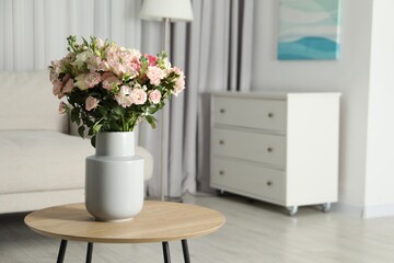 Beautiful bouquet of fresh flowers in vase on wooden coffee table indoors, space for text