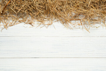 Dried hay on white wooden background, flat lay. Space for text