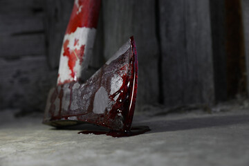 Axe with blood on floor indoors, closeup. Space for text