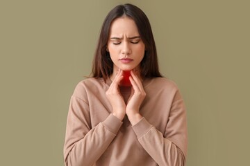 Young woman with sore throat on color background