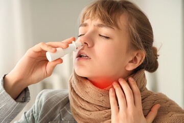 Ill woman using nasal drops in office