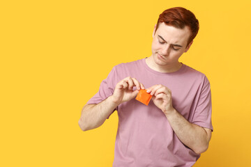 Young man with condom on yellow background. Safe sex concept