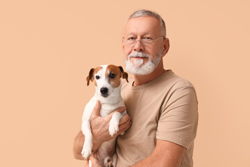 Middle-aged man and cute dog on beige background