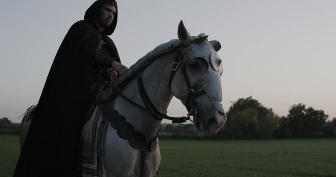 Silhouette of epic knight on armored horse in slow motion - dusk