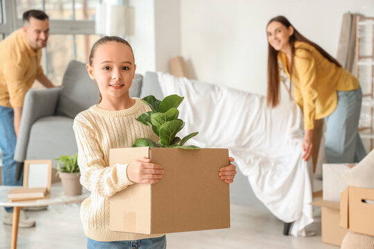 Little girl with cardboard box in room on moving day