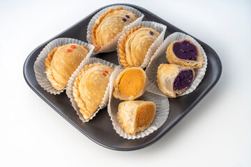 Curry puffs purple and sweet potatoeon black plate on white background, Curry puff pastry on white background.